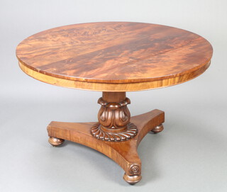 A William IV circular mahogany snap top breakfast table raised on a carved column and triform base ending in spade feet 71cm h x 115cm diam. 