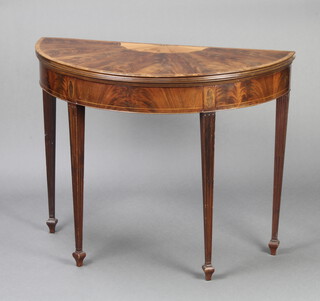An Edwardian Sheraton Revival inlaid mahogany demi-lune card table with crossbanded top, raised on square tapered and fluted supports, spade feet 73cm h x 93cm w x 44cm d 