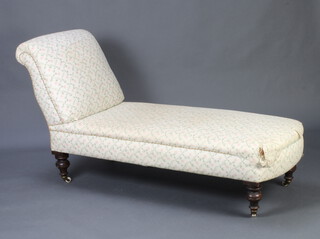 A Victorian chaise longue/day bed upholstered in floral patterned material, raised on turned supports with ceramic casters 94cm h x 180cm l x 60cm w 