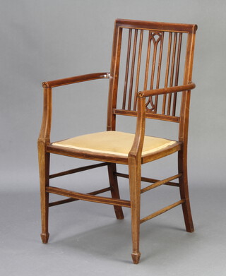 An Edwardian inlaid mahogany stick and rail back open armchair, raised on square tapered supports 