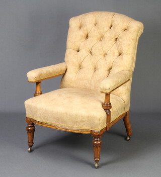A Victorian inlaid mahogany open armchair, the back upholstered in yellow buttoned material, raised on turned supports with brass caps and castors   