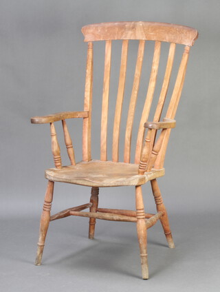 A 19th Century bleached beech and elm stick and rail back kitchen carver chair, raised on turned supports, signs of old but treated worm to the rear right hand leg 