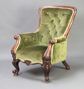 A Victorian mahogany show frame armchair upholstered in green buttoned material raised on carved cabriole supports 
