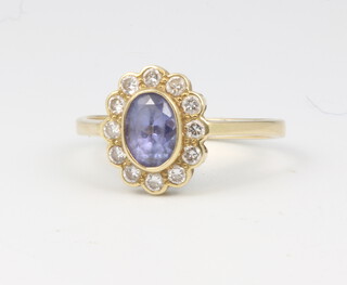 An 18ct yellow gold oval amethyst and diamond cluster ring, centre stone approx. 0.75ct, surrounded by 12 brilliant cut diamonds approx. 0.4ct, size N 1/2, 2.8 grams