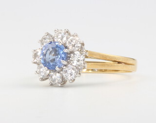 An 18ct yellow gold sapphire and diamond cluster ring, centre stone approx. 0.65ct surrounded by 8 brilliant cut diamonds approx. 0.8ct, size N 1/2