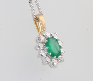 An 18ct yellow gold oval emerald and diamond cluster pendant 18mm on a silver chain, centre stone approx. 1ct, diamonds 0.5ct