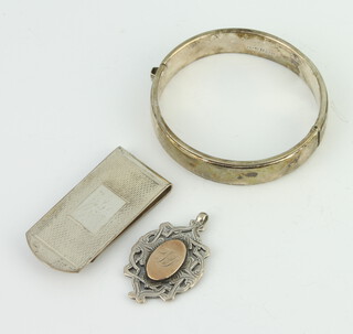 A silver money clip, bangle and fob 44 grams