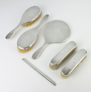 A silver engine turned dressing table set comprising hand mirror, 2 clothes brushes, 2 hair brushes and a comb back 