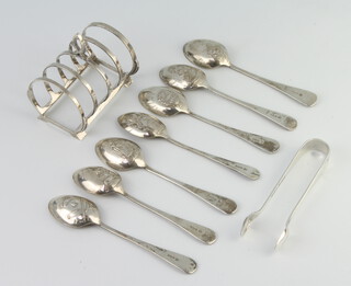 A silver Art Deco style 5 bar toast rack, London 1950, 7 teaspoons and pair of tongs, 169 grams
