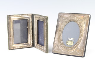 A modern repousse silver oval photograph frame, rubbed marks, a double folding ditto 