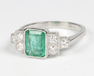 A platinum Art Deco style emerald and diamond ring, the centre cut emerald approx. 1.1ct flanked by 6 brilliant cut diamonds 0.3ct, size M 1/2, 4.4 grams 