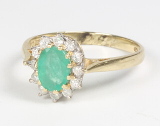 An 18ct yellow gold oval emerald and diamond cluster ring, size P, 3.3 grams 