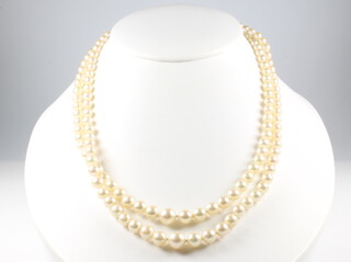 A double strand of cultured pearls with a 9ct yellow gold cabochon garnet and seed pearl clasp 46cm 