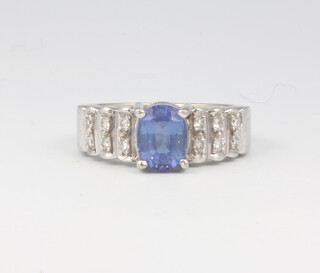 An 18ct white gold tanzanite and diamond dress ring, the oval stone approx. 1.5ct set with 12 brilliant cut diamonds approx. 0.25ct, 9.4 grams, size P 1/2