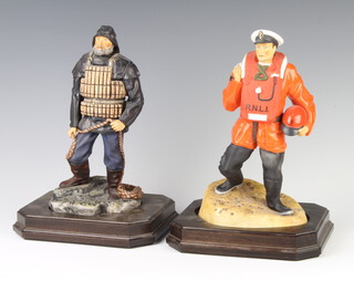 An Ashmor bone china figure of an RNLI lifeboatman 1982 no.155/250 26cm, ditto of an RNLI lifeboatman 1882 no. 155/250 26cm, both on a wooden stand 