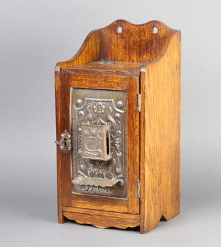 An Art Nouveau and embossed metal hanging smokers cabinet with raised back, the pressed metal door incorporating a match slip 32cm h x 15cm x 14cm 
