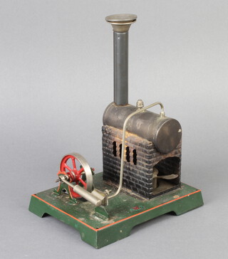 A tin plate model of a stationary steam engine marked DC complete with funnel 22cm h x 12cm x 14cm (some light rust)