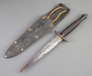 A Fairbairn Sykes type dagger with 17cm blade and brass cross bar, complete with leather scabbard 