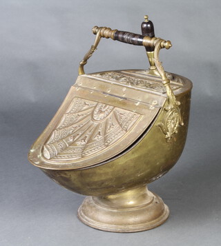 A Benham & Froud Victorian embossed brass helmet shaped coal scuttle with turned wooden handle (cracked) and complete with shovel 49cm h x 52cm w x 31cm d 