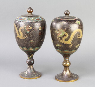 A near pair of Japanese black ground cloisonne enamelled urns and covers decorated running dragons 25cm x 10cm 