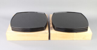 Ten Chinese shaped black lacquered trays contained in a pine carrying case 36cm x 36cm 