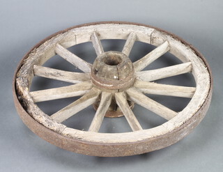 A wooden and iron 12 spoked cart wheel 85cm diam. 