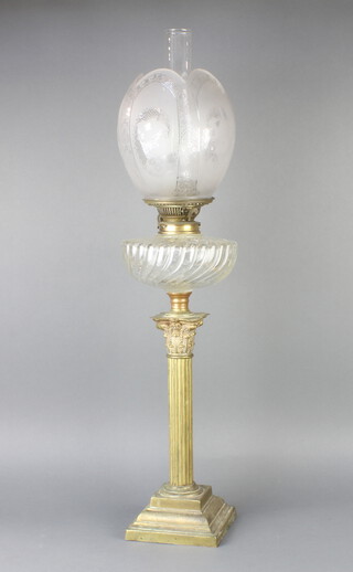 A brass oil lamp with etched glass shade, clear glass chimney and glass reservoir, raised on a brass Corinthian column capital base 76cm h x 15cm w x 14cm d 
