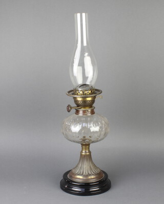 A Victorian faceted glass oil lamp reservoir raised on an embossed gilt metal base with black glazed ceramic socle base 33cm x 15cm 