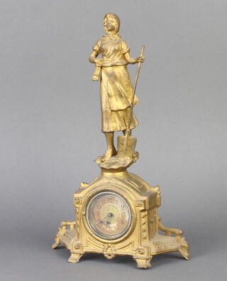 An Edwardian timepiece with paper dial and Arabic numerals contained in a gilt painted spelter case surmounted by figure of a lady gardener 
