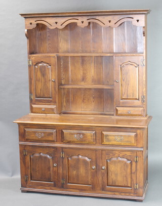 An 18th Century style oak dresser with moulded and dentil cornice, fitted 2 shelves flanked by a pair of cupboards enclosed by panelled doors with H framed brass hinges, the base fitted 3 long drawers above triple cupboard 189cm h x 173cm w x 49cm d 