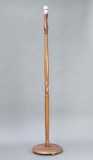 A turned oak standard lamp on a circular base 147cm h x 30cm diam. 