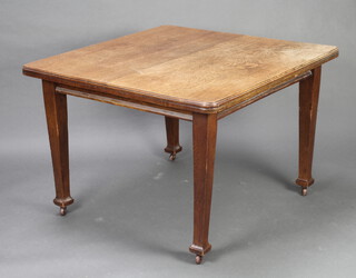 Wolfe and Hollander, an Edwardian Art Nouveau oak extending dining table raised on square tapered supports with 1 extra leaf 73cm h x 105cm l x 104cm w 