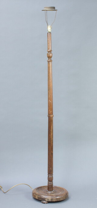 A turned oak standard lamp raised on a circular base 146cm h x 38cm diam. (slight split to the base) 
