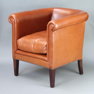 A tub back armchair upholstered in light brown leather 