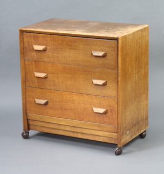 A 1950's oak chest of 3 long drawers with shaped handles 71cm h x 68cm w x 41cm d 
