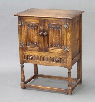 A carved oak cabinet with linenfold decoration above 1 long drawer, raised on turned and block supports 80cm h x 62cm w x 40cm d 