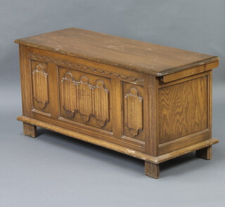 An oak coffer with hinged lid and panel decoration, raised on square supports 47cm h x 94cm w x 37cm d (some scratches to the top) 