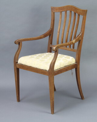 An Edwardian inlaid mahogany stick and rail back open armchair with upholstered drop in seat, raised on square tapered supports 