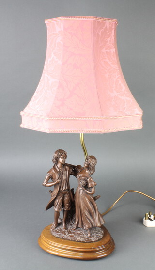A bronzed table lamp supported by 2 figures 26cm h x 20cm w x 20cm d 