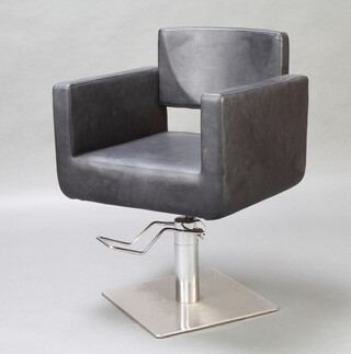 A chrome and black rexine revolving and adjustable barbers seat 