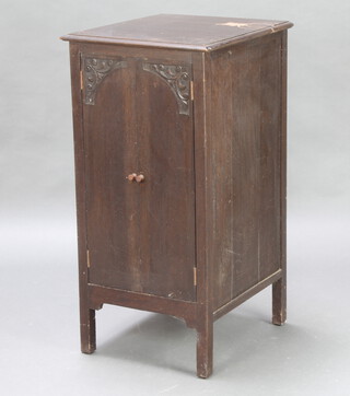 A 1930's oak music cabinet enclosed by panelled doors 94cm h x 47cm w x 53cm d (ring mark to the top) 