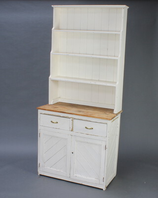 An Arts and Crafts style white painted pine dresser with 3 tier waterfall top above a recess, the base fitted 2 drawers above cupboard 203cm h x 90cm w x 45cm d  (split to top) 