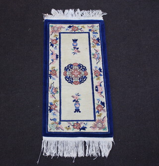 A blue and white ground Chinese rug 128cm x 62cm (slight stain to centre and fringe) 