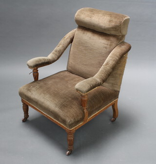A Victorian oak show frame open arm chair upholstered in brown material raised on turned supports 