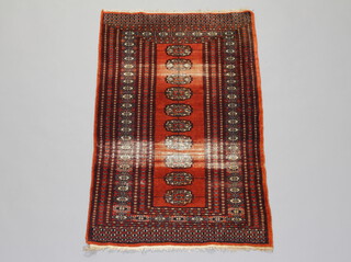 A brown and white ground Bokhara rug with 10 octagons to the centre with a multi row border 122cm x 77cm (in wear, fringe reduced) 