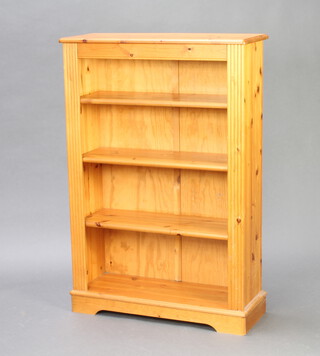 A pine bookcase with adjustable shelves, raised on a platform base 120cm h x 82cm w x 30cm d 