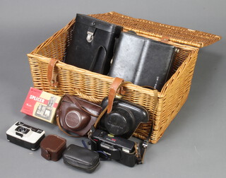 A Fortnum and Mason wicker picnic hamper containing a Bell and Howell autoload Super 8 camera/431, an auto carina camera, a Mamiya camera, a Vivitar D.535 camera, a Konipak 300 camera, light meter etc 