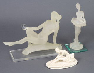 A perspex sculpture of a reclining naked lady, 25cm h x 33cm w x 12cm d, ditto standing ballerina 30cm x 10cm x 10cm and a a resin figure of a seated ballerina on an oval base 10cm x 18cm x 10cm 