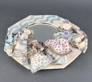 An octagonal ceramic framed mirror decorated with figures 