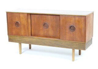 A stylish mid Century teak sideboard enclosed by sliding doors raised on square supports 73cm h x 137cm w x 42cm d  